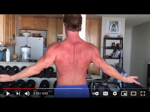 Video still: Scott Aloha, seen from behind, lifting his arms for the upper body assessment